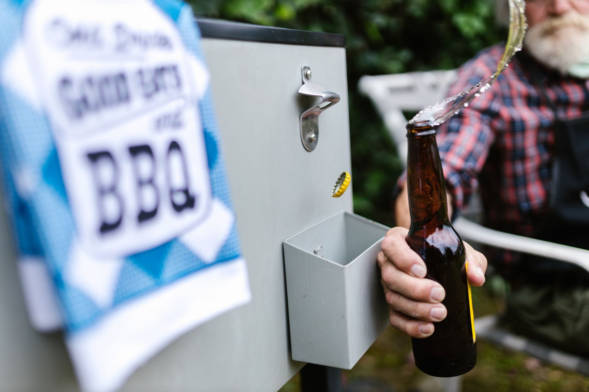 Czy piwo naprawdę obniża testosteron? fakty o alkoholu i formie mężczyzny Starszy mężczyzna otwiera butelkę piwa na plenerowym grillu